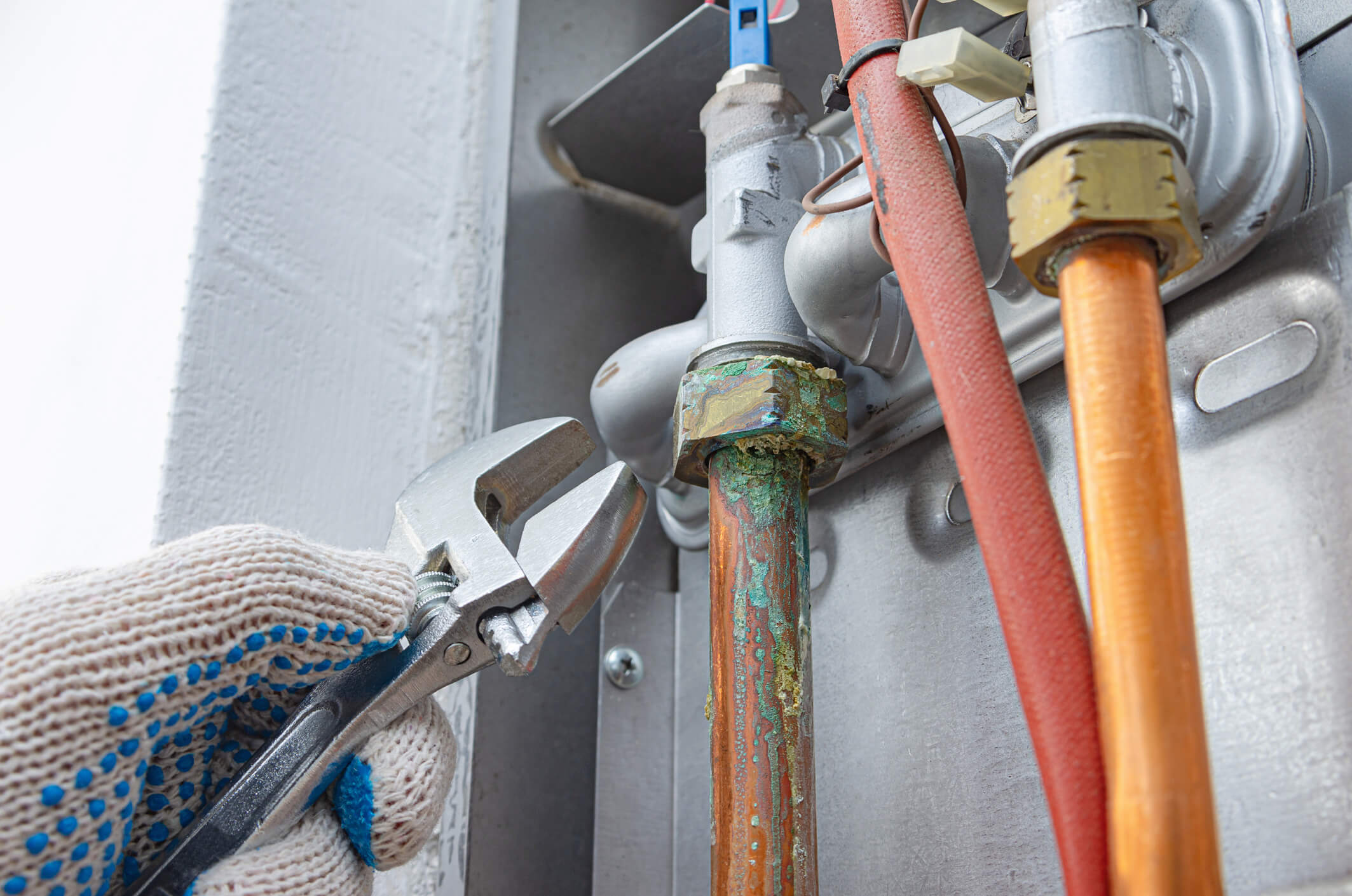 person tightening pipe with a wrench